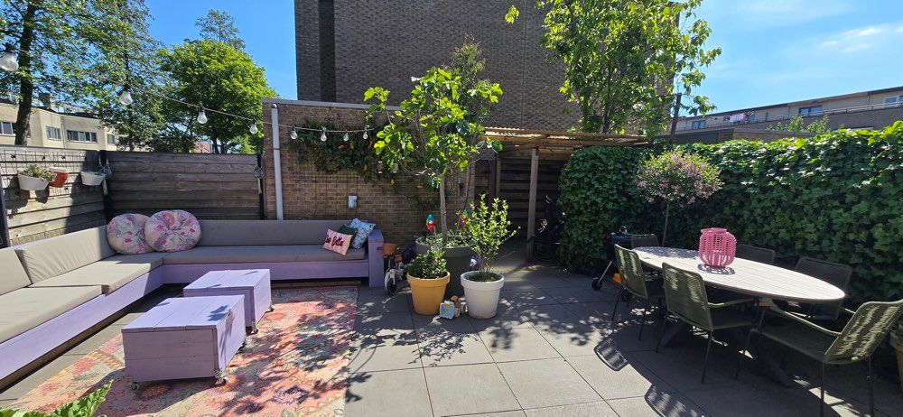 Ruime tuin met loungehoek en planten om buiten te spelen.